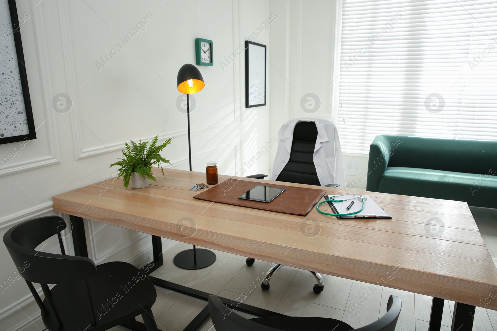 Photo of Modern medical office interior with doctor's workplace and sofa