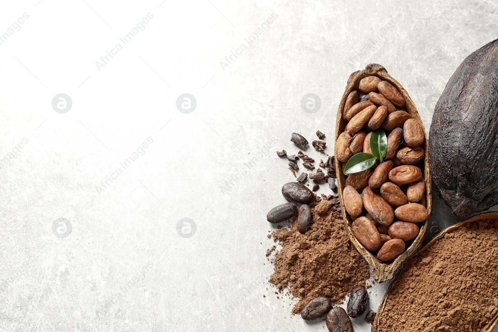 Photo of Cocoa pods, beans and powder on light table, flat lay. Space for text