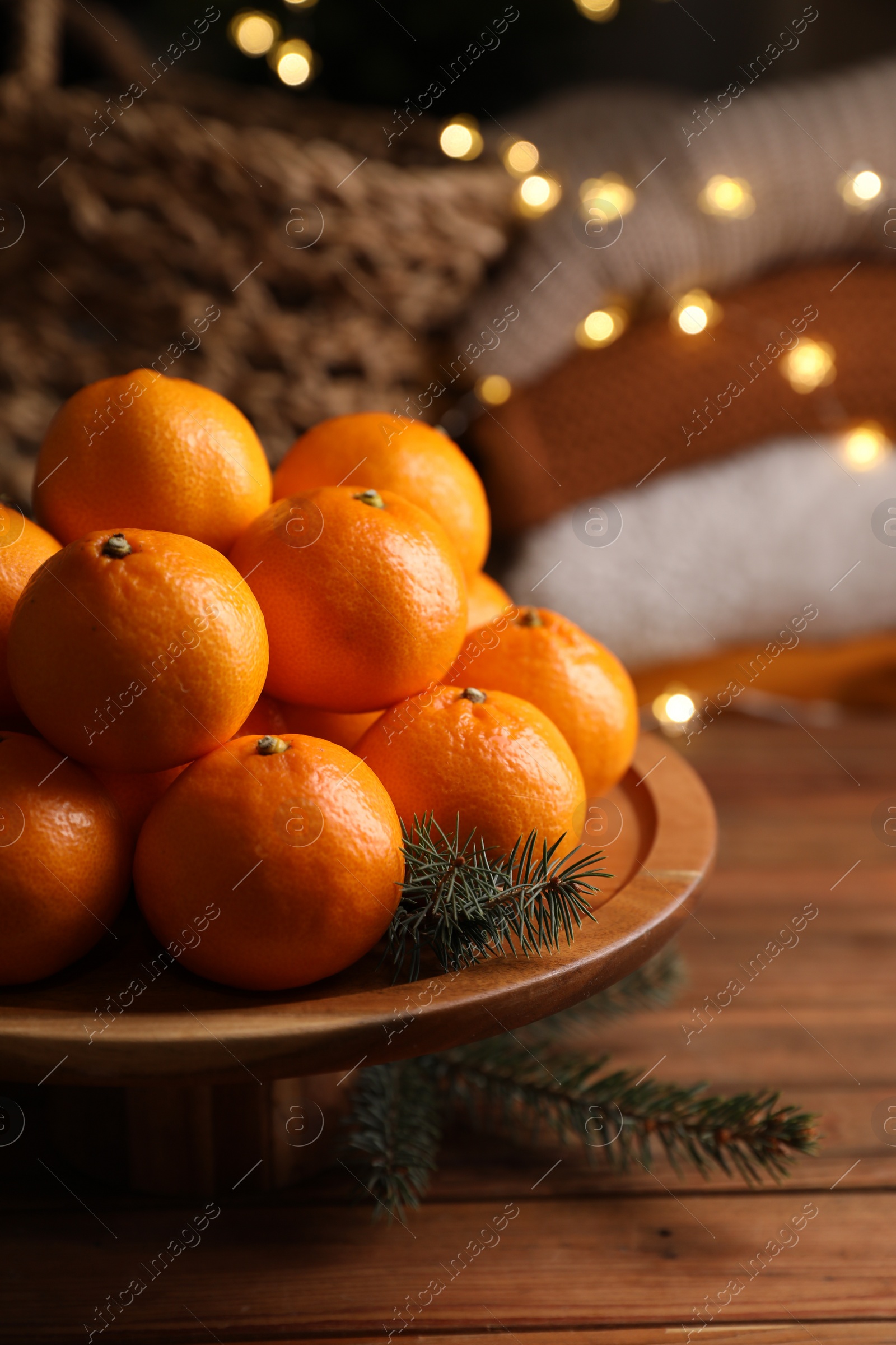 Photo of Stand with delicious ripe tangerines on wooden table