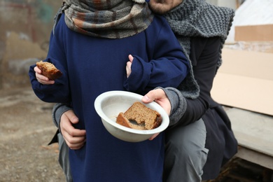 Poor father and child with bread at dump, closeup