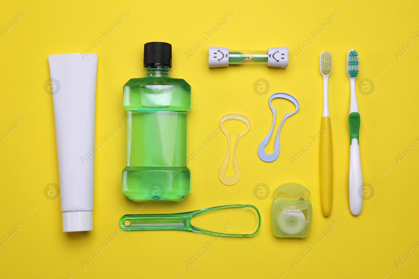 Photo of Flat lay composition with tongue cleaners and teeth care products on yellow background