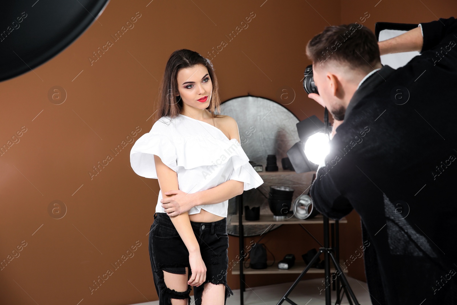 Photo of Beautiful young model posing for professional photographer in studio