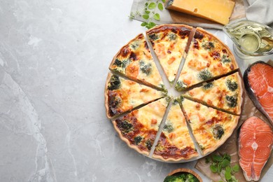 Photo of Delicious homemade quiche and ingredients on light gray marble table, flat lay. Space for text
