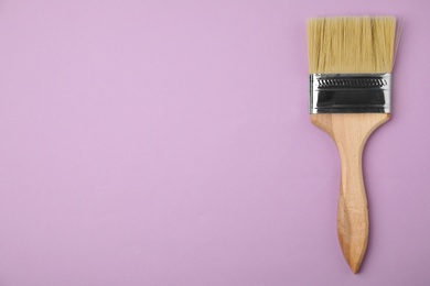 Photo of Paint brush on color background, top view. Space for text