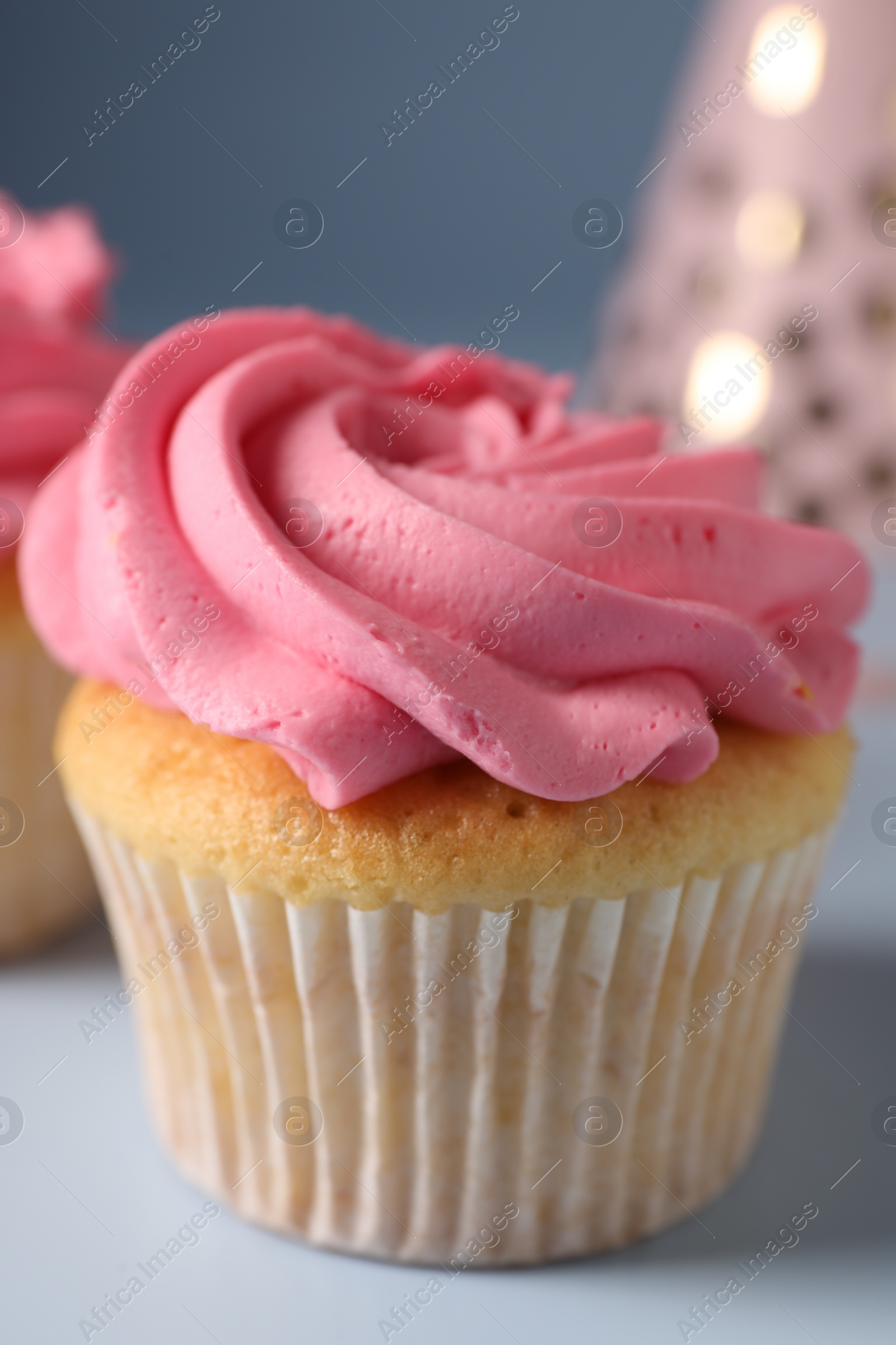 Photo of Delicious cupcake with bright cream on light background, closeup