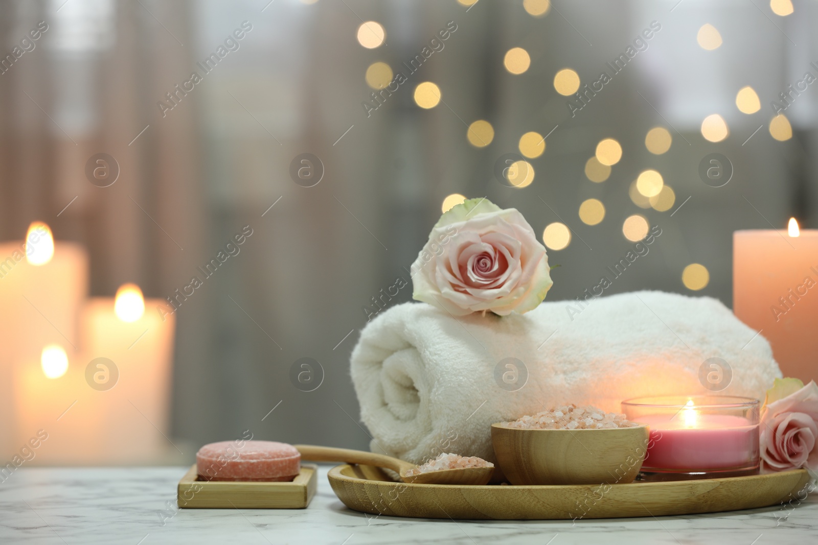 Photo of Beautiful composition with different spa products and rose flower on white marble table. Space for text