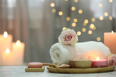 Beautiful composition with different spa products and rose flower on white marble table. Space for text