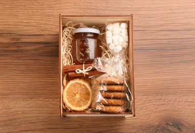 Box with stylish craft gift set on wooden table, top view