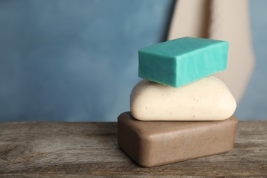 Photo of Stack of different soap bars on table. Space for text