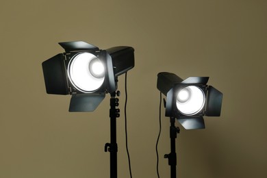 Photo of Modern spotlights against beige background. Professional stage equipment