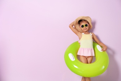 Photo of Cute little girl with inflatable ring on color background