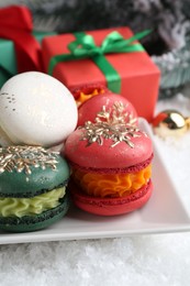 Beautifully decorated Christmas macarons and festive decor on snow, closeup