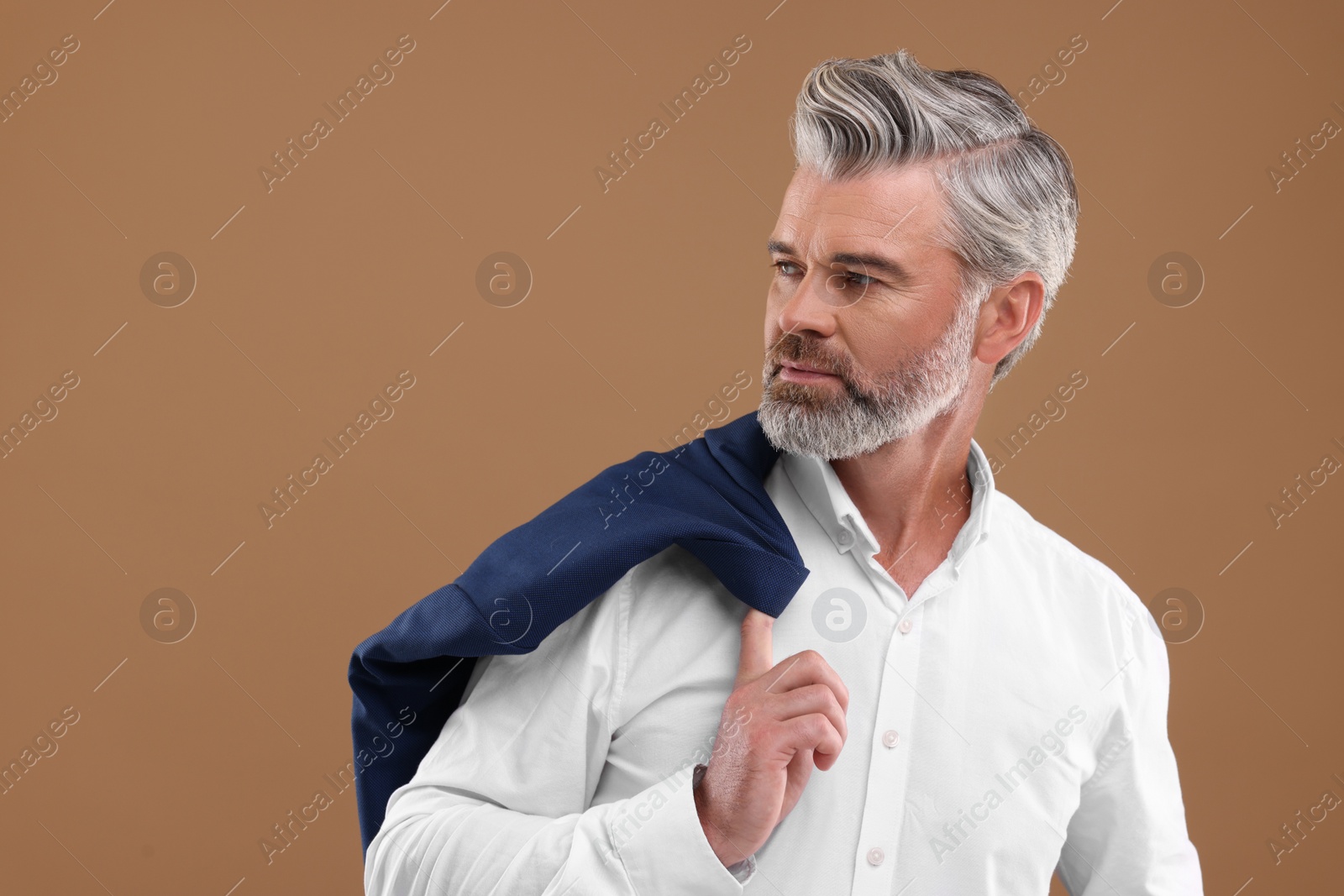 Photo of Portrait of confident man with beautiful hairstyle on light brown background. Space for text