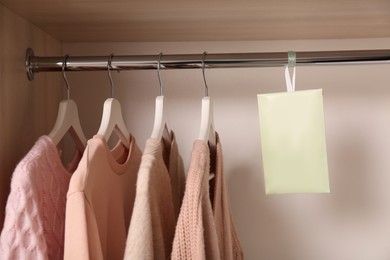Photo of Scented sachet and clothes hanging in wardrobe