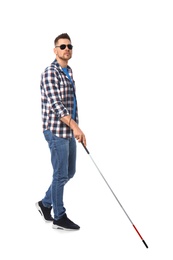 Blind man in dark glasses with walking cane on white background