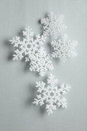 Beautiful decorative snowflakes hanging on light grey background