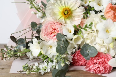 Photo of Bouquet of beautiful flowers on wooden table, closeup
