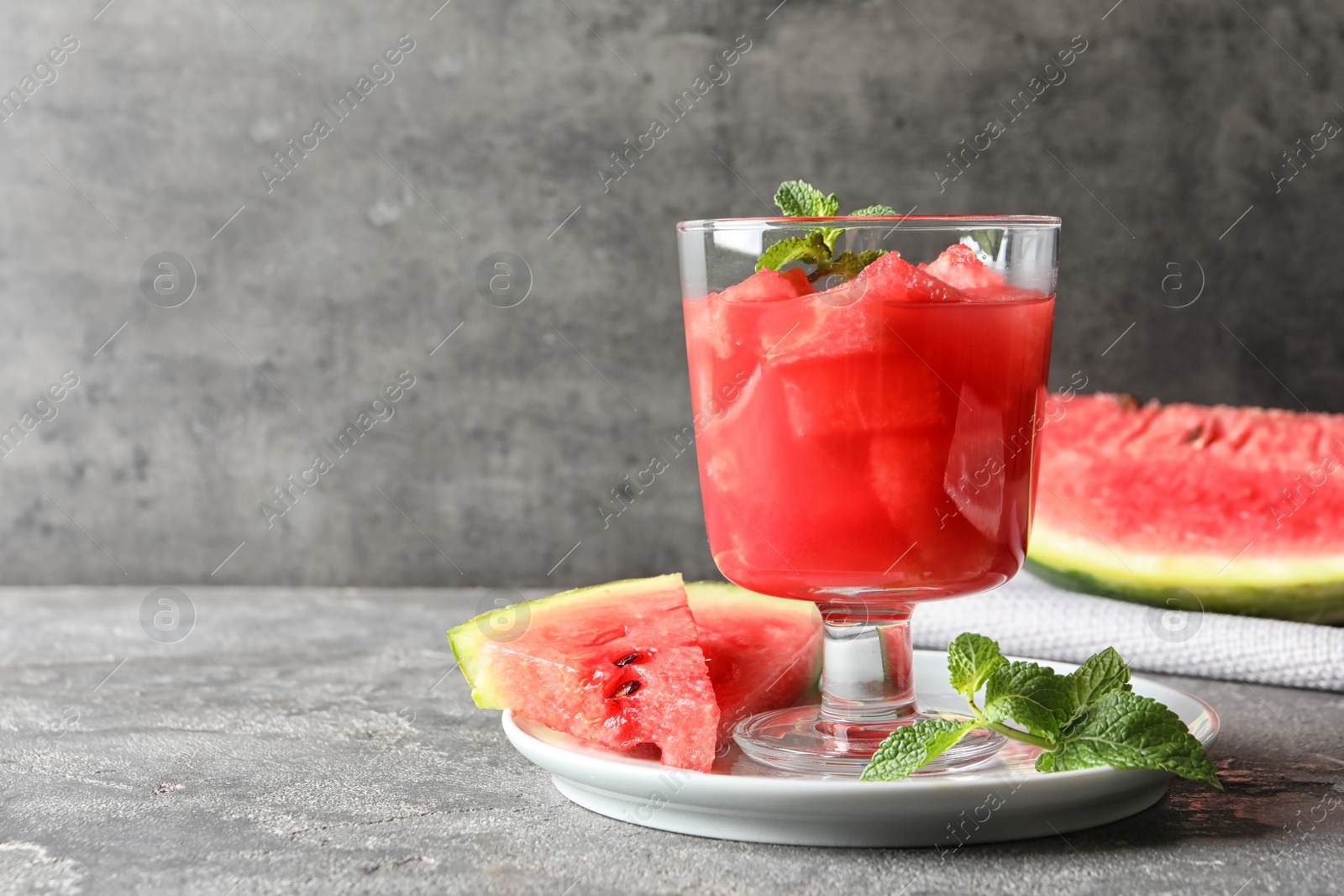 Photo of Tasty summer watermelon drink served on table against gray background. Space for text