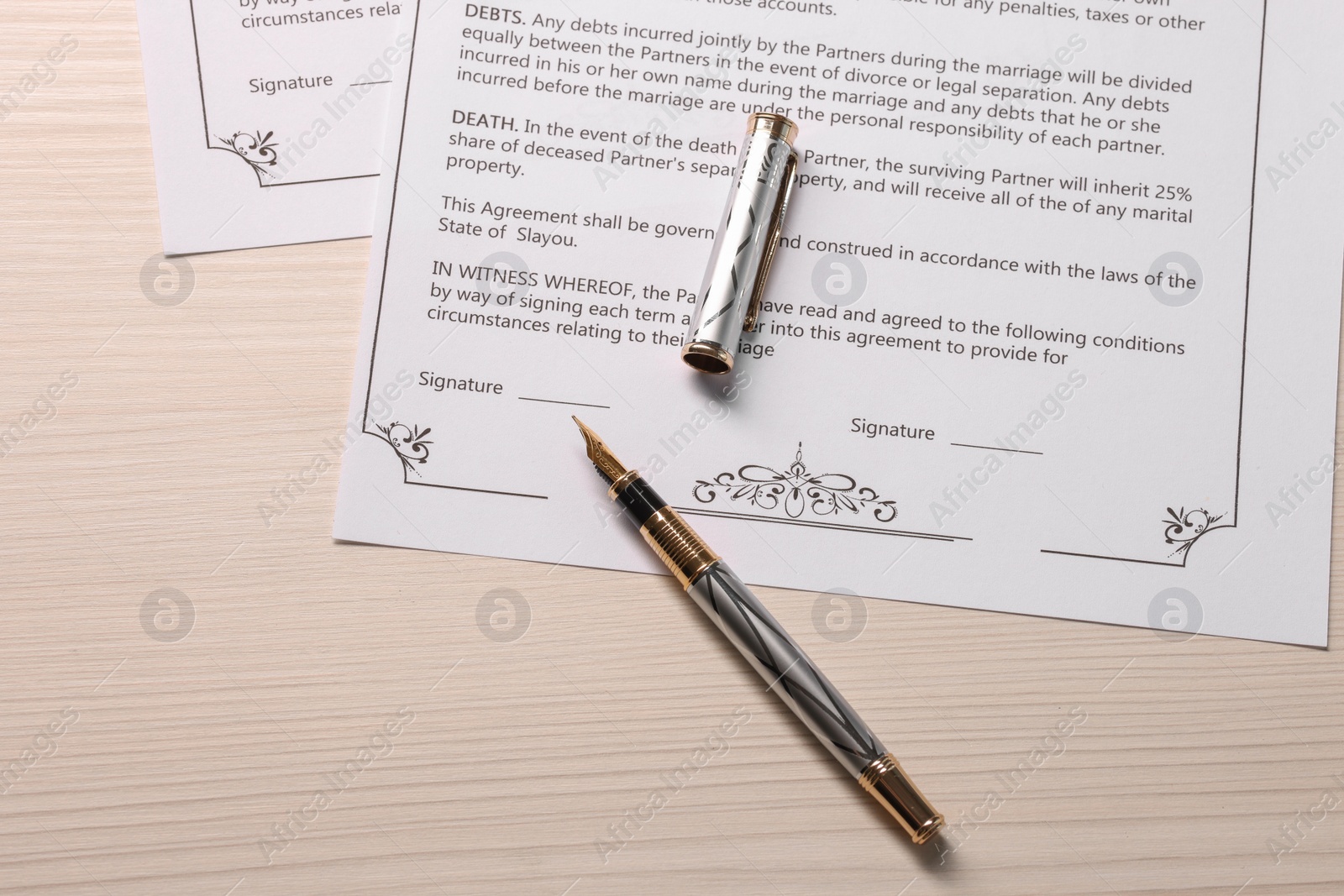 Photo of Marriage contracts and pen on light wooden table, top view