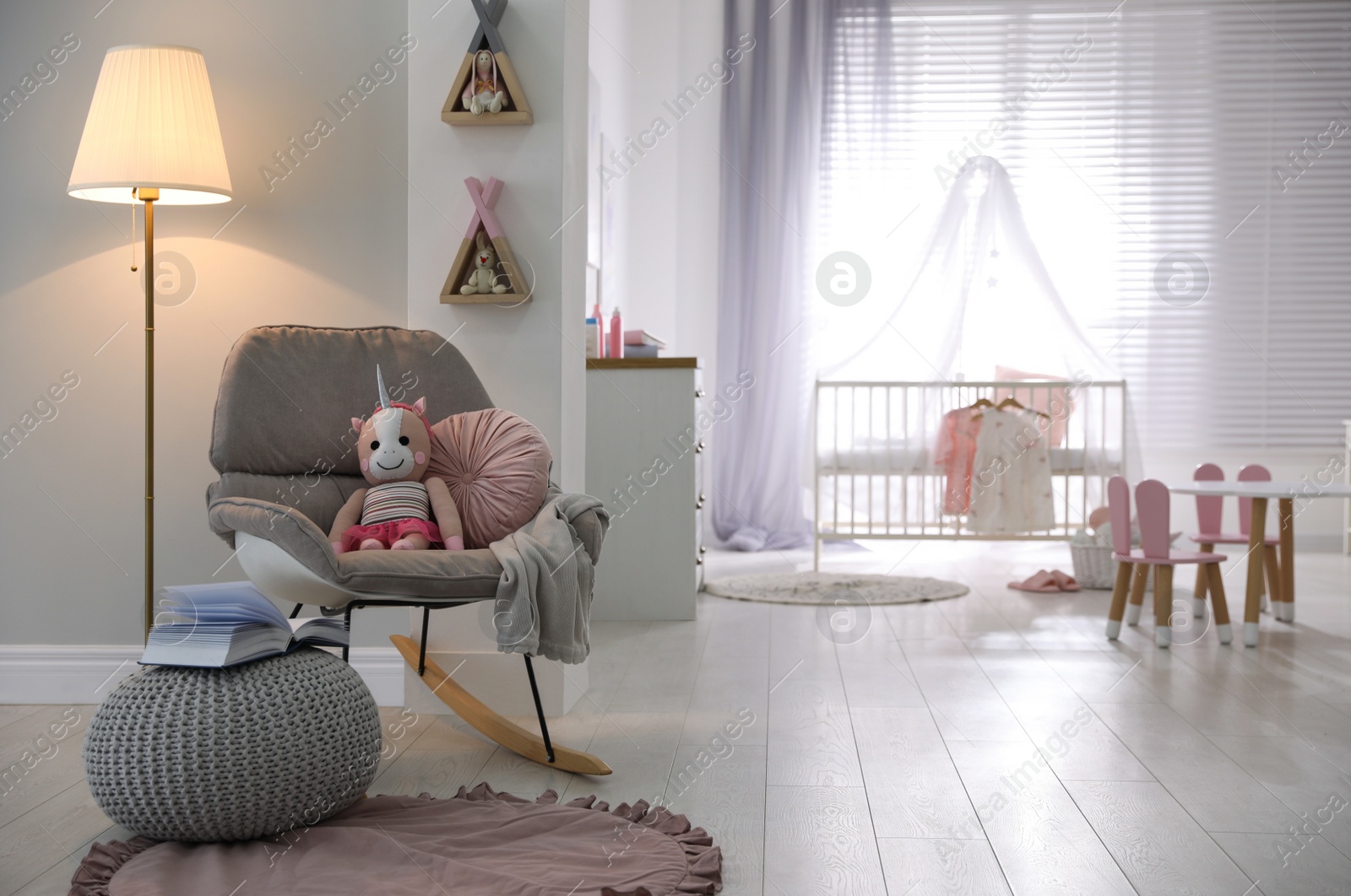 Photo of Cozy baby room interior with comfortable rocking chair