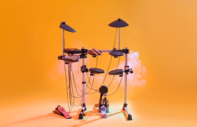 Photo of Modern electronic drum kit and smoke on yellow background. Musical instrument