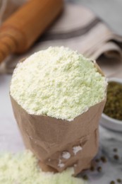 Photo of Mung bean flour in paper bag and seeds on white marble table, closeup