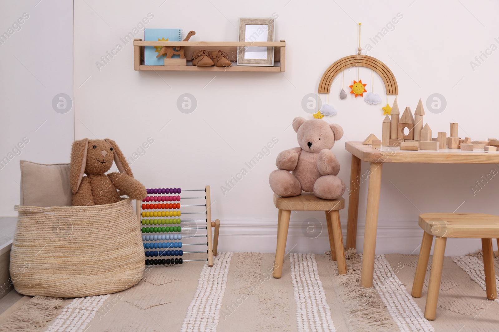 Photo of Children's room interior with stylish wooden furniture, toys and decorative elements