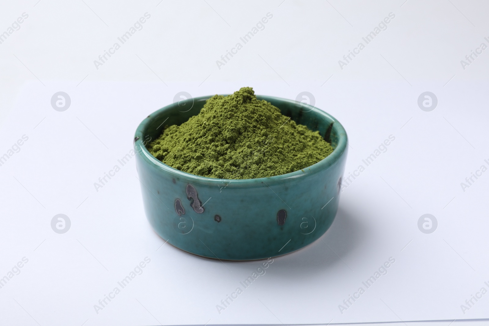Photo of Green matcha powder in bowl isolated on white