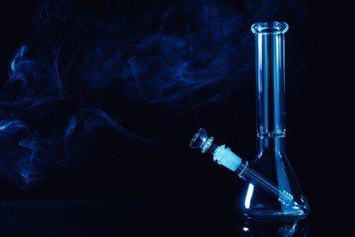 Glass bong and smoke on black background, space for text. Smoking device