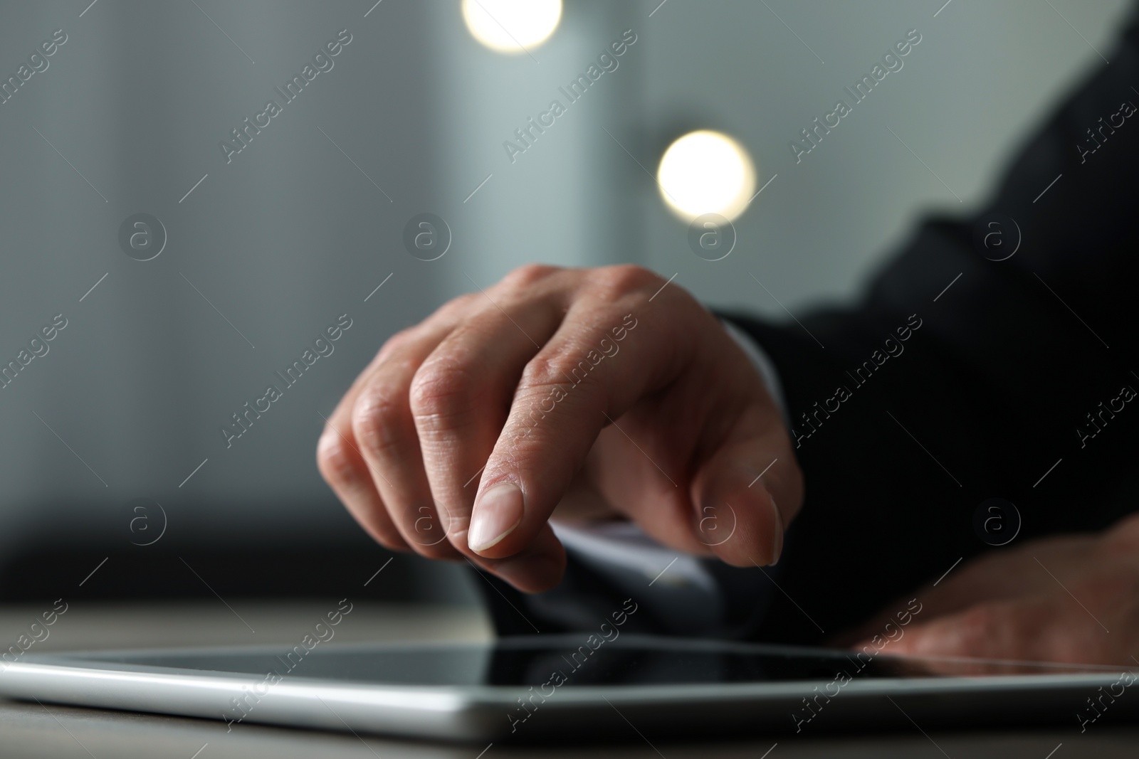 Photo of Closeup view of man using new tablet at desk indoors