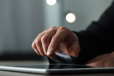 Closeup view of man using new tablet at desk indoors