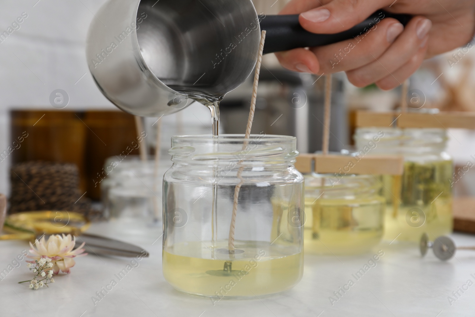 Photo of Woman making candles at white table, closeup