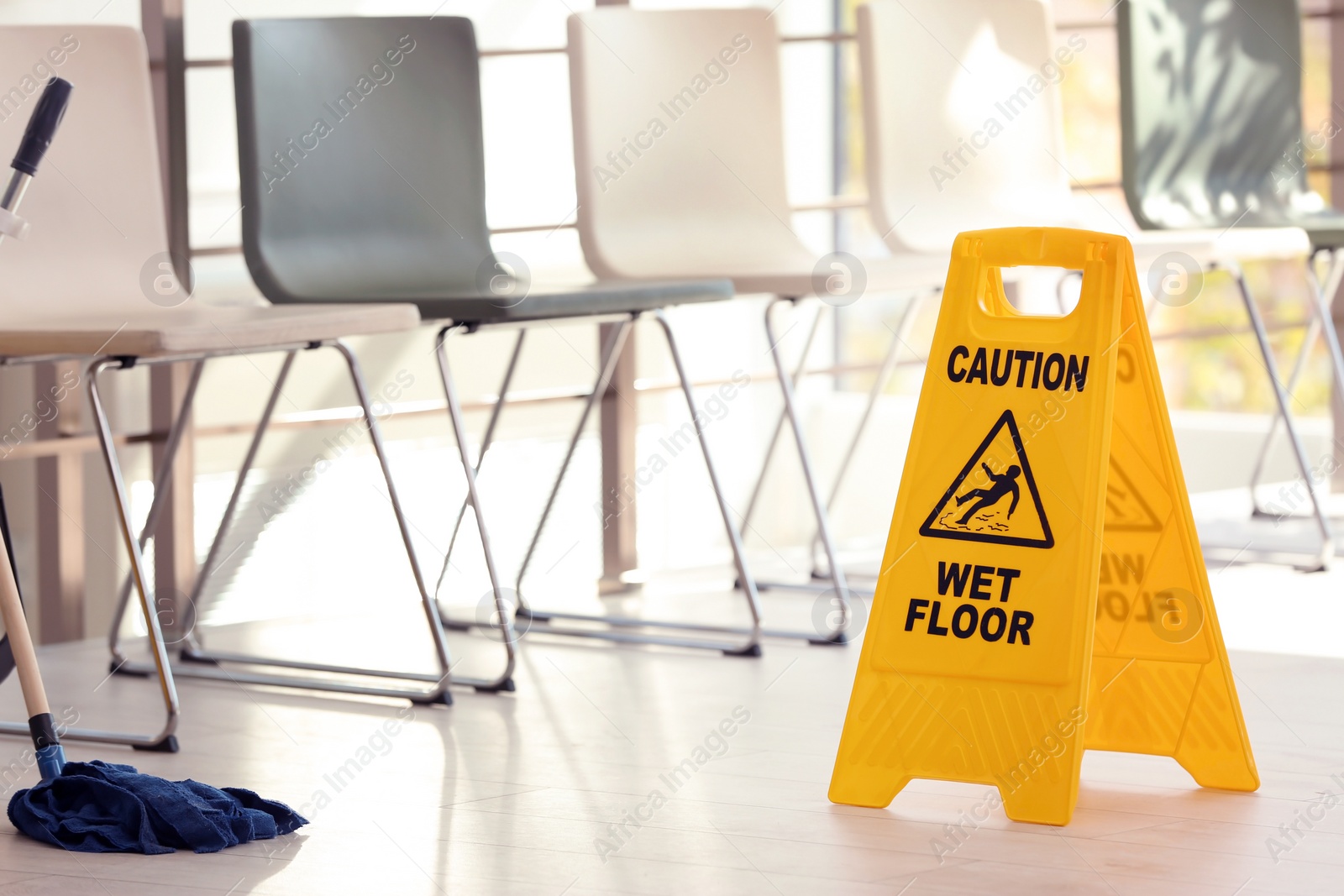 Photo of Safety sign with phrase Caution wet floor and mop, indoors. Cleaning service