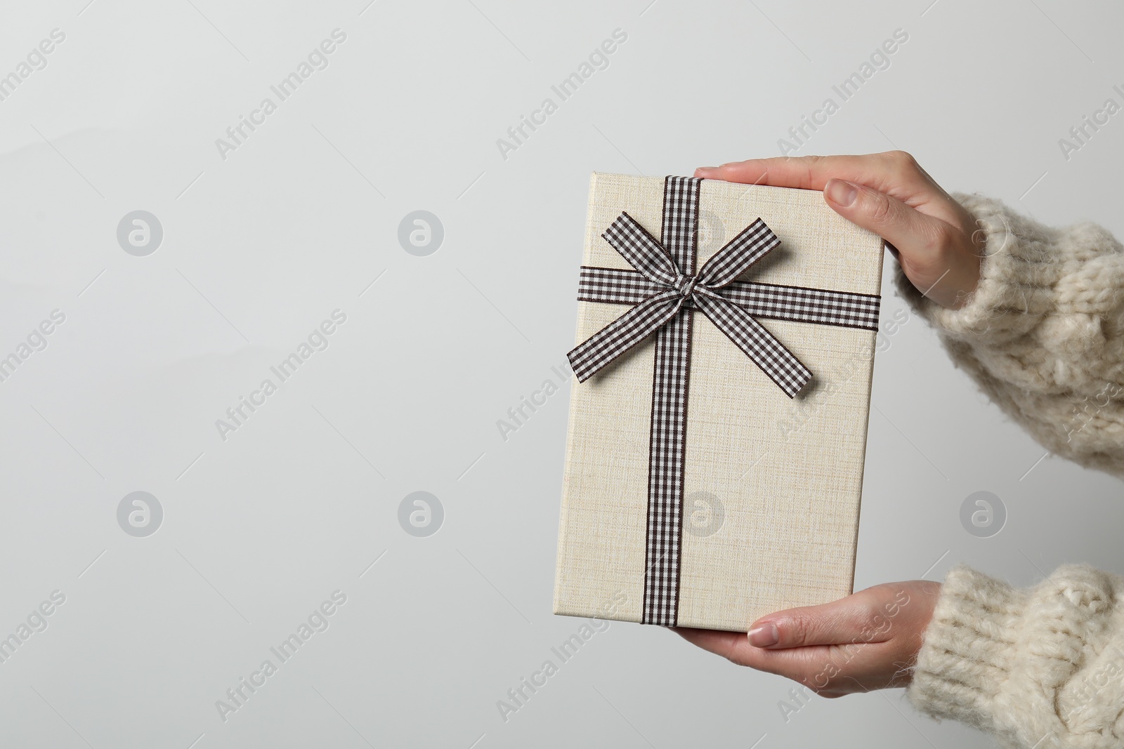 Photo of Christmas present. Woman holding gift box against white background, closeup. Space for text