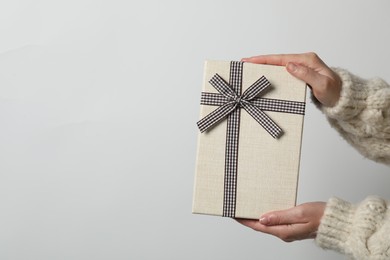 Photo of Christmas present. Woman holding gift box against white background, closeup. Space for text