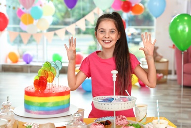 Photo of Happy girl in room decorated for birthday party