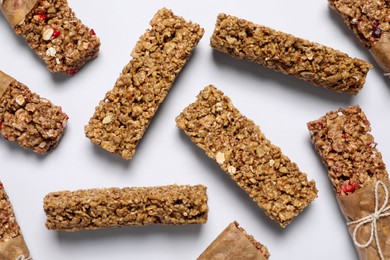 Photo of Tasty granola bars on white background, flat lay