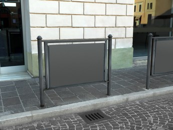 Photo of Blank advertising board on city street near building. Mockup for design