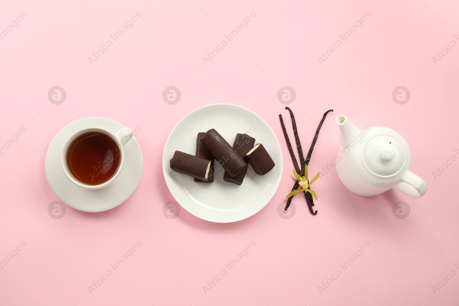 Photo of Glazed curd cheese bars, vanilla pods and tea on pink background, flat lay