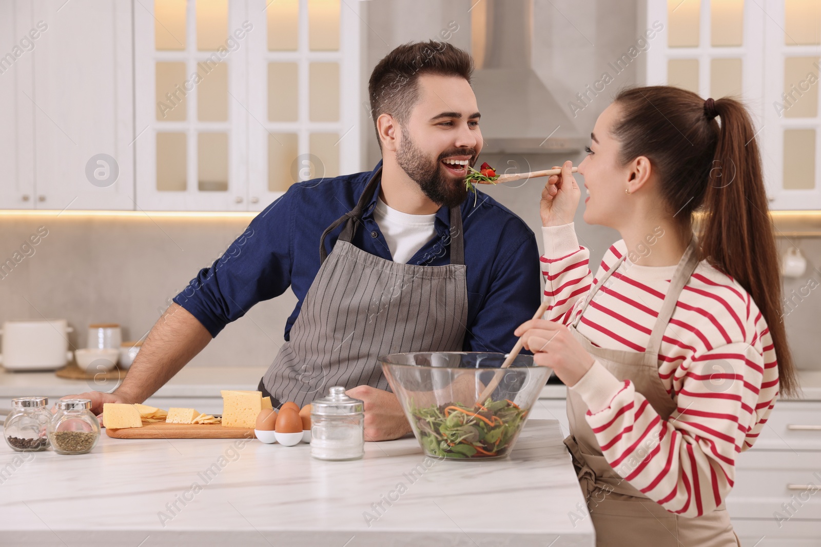 Photo of Happy lovely couple cooking together in kitchen