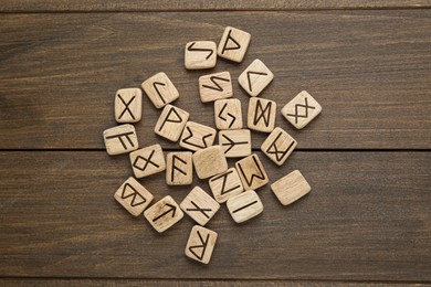 Runes with different symbols on wooden table, flat lay