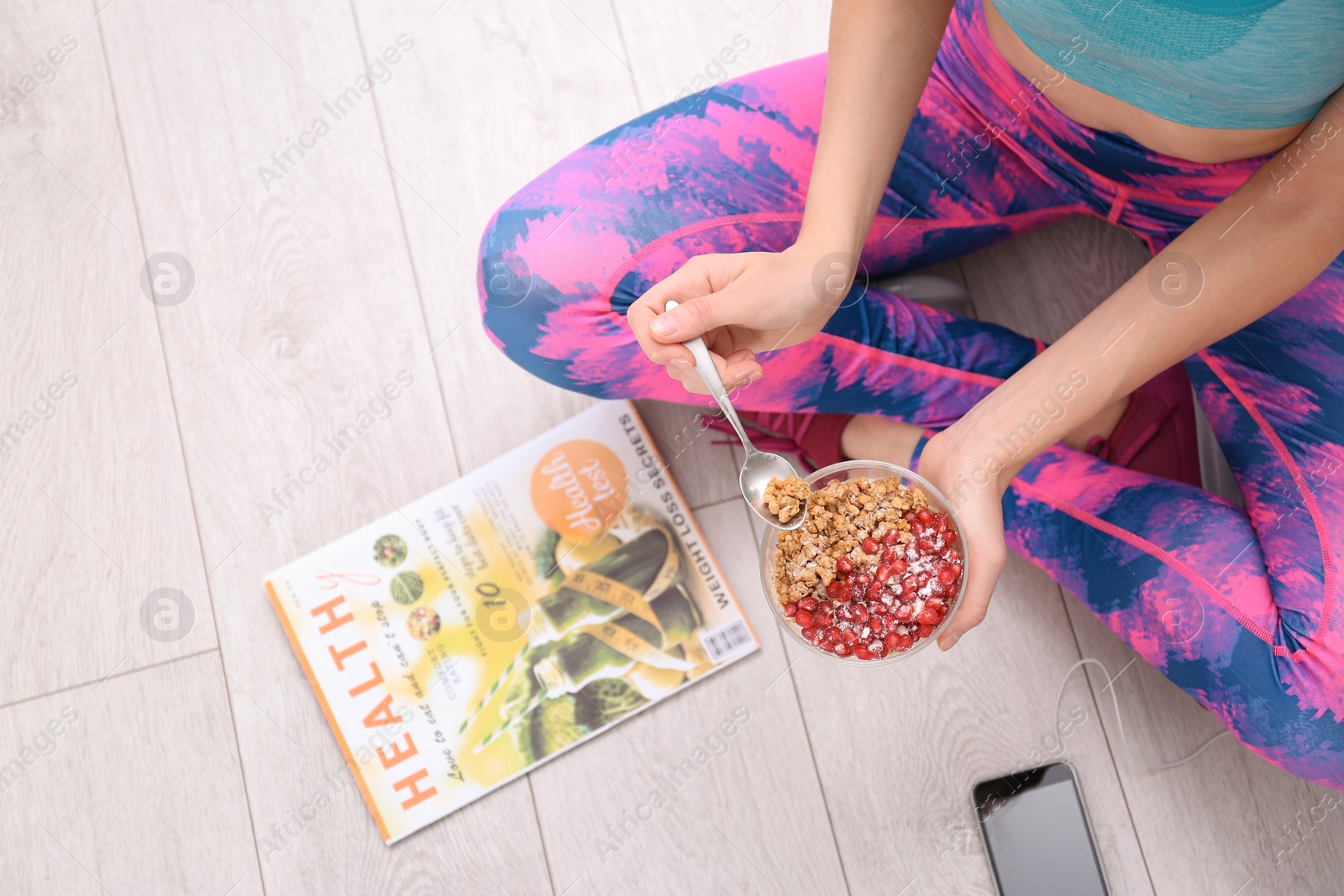 Photo of Young woman in fitness clothes having healthy breakfast at home, top view