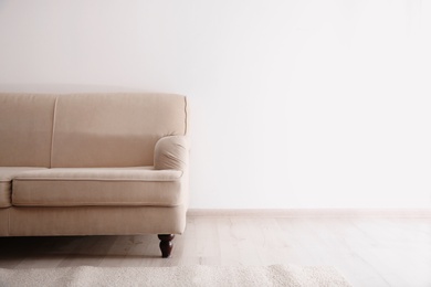 Photo of Simple living room interior with comfortable sofa near white wall. Space for text