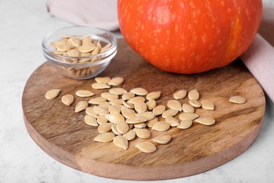 Photo of Fresh pumpkin and vegetable seeds on white table, closeup