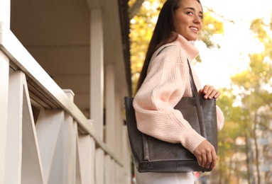 Young woman with stylish shopper bag outdoors