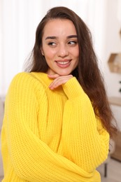 Beautiful young woman in stylish warm sweater at home