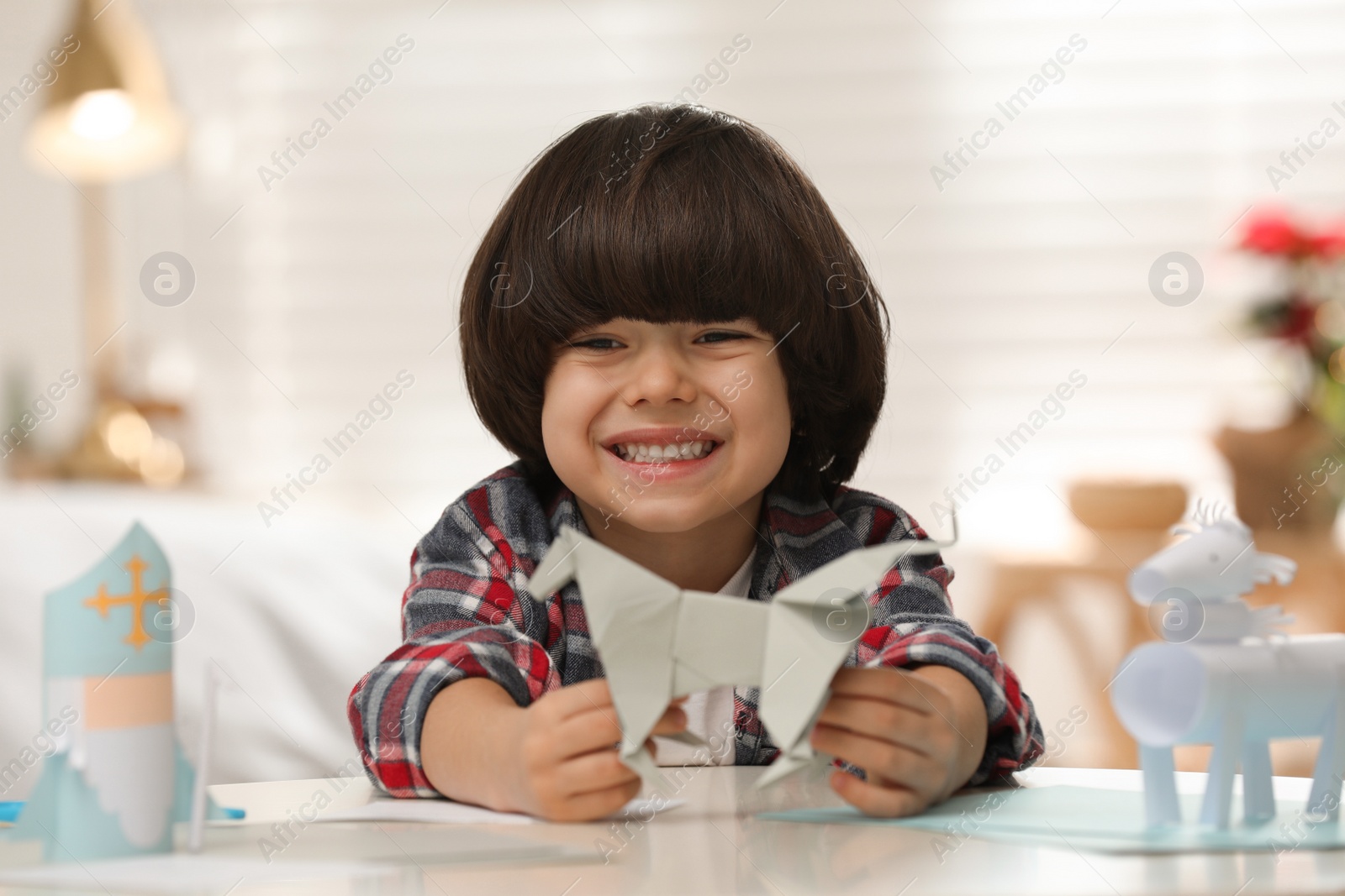 Photo of Cute little boy with paper toy for Saint Nicholas day at home