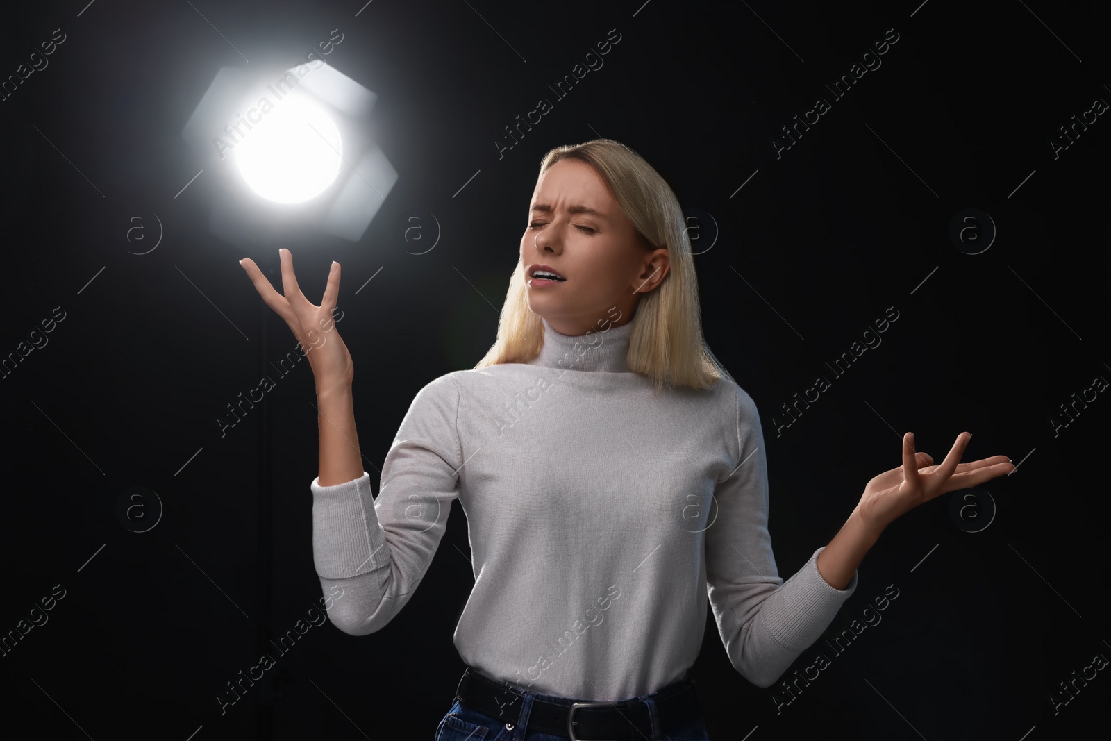 Photo of Casting call. Emotional woman performing on black background