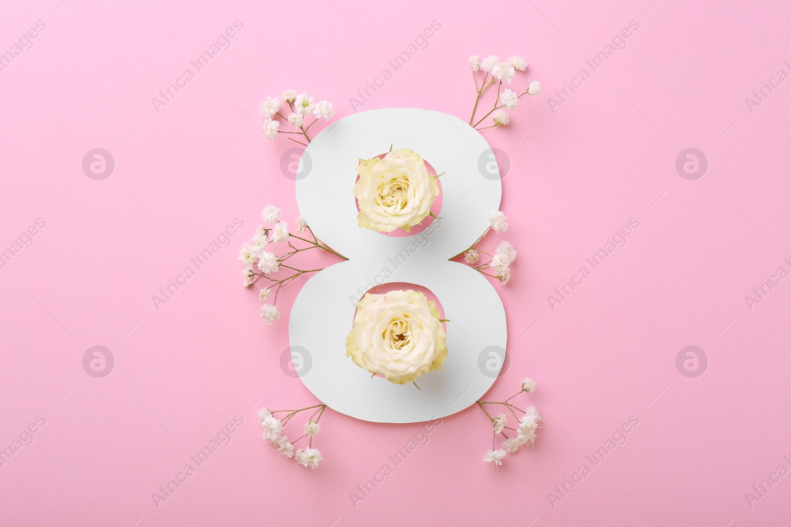 Photo of Paper number 8 and beautiful flowers on pink background, top view
