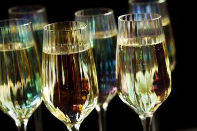 Glasses of champagne on black background, closeup